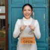 Small Business Owner holding "Open" sign