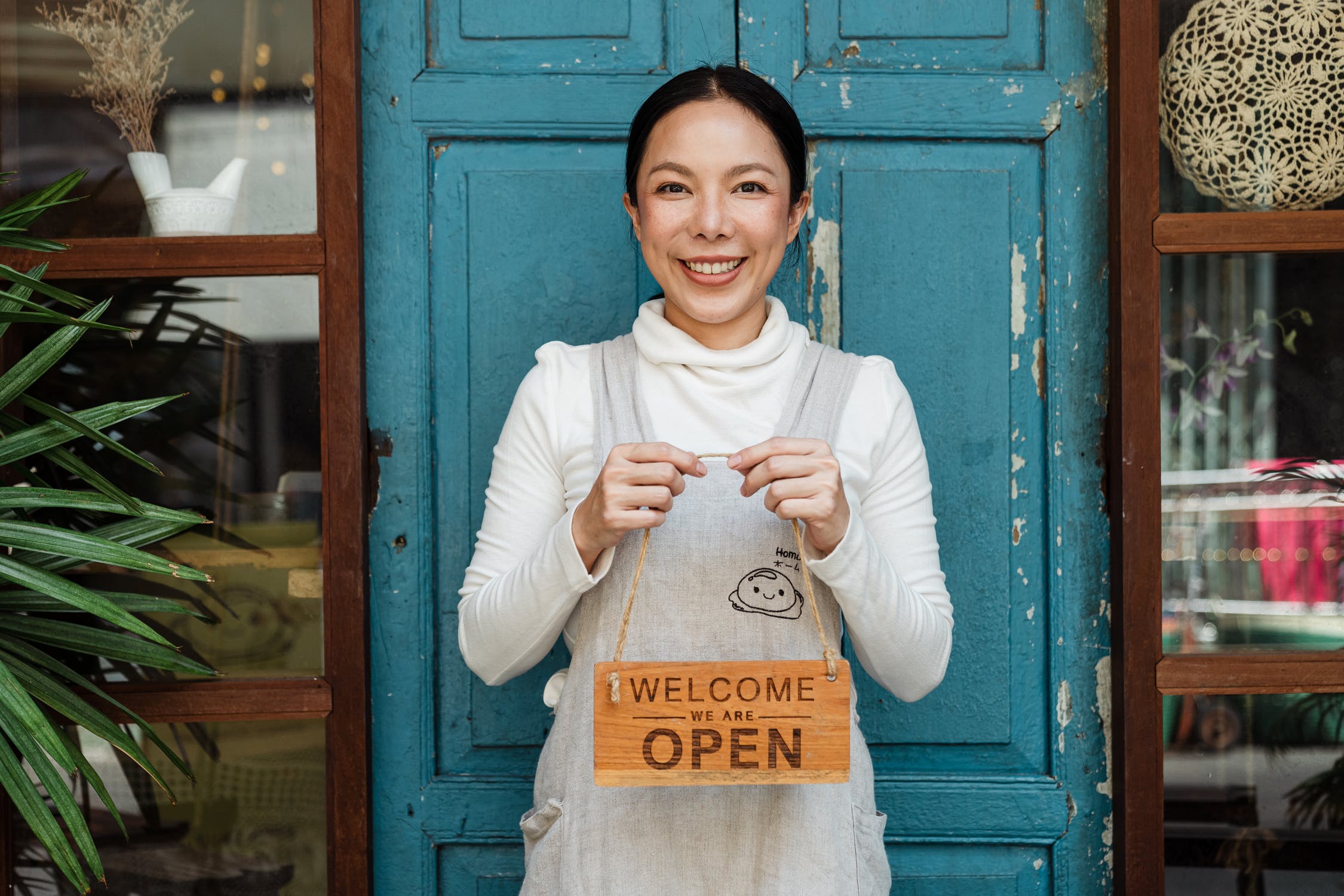 Small Business Owner holding "Open" sign