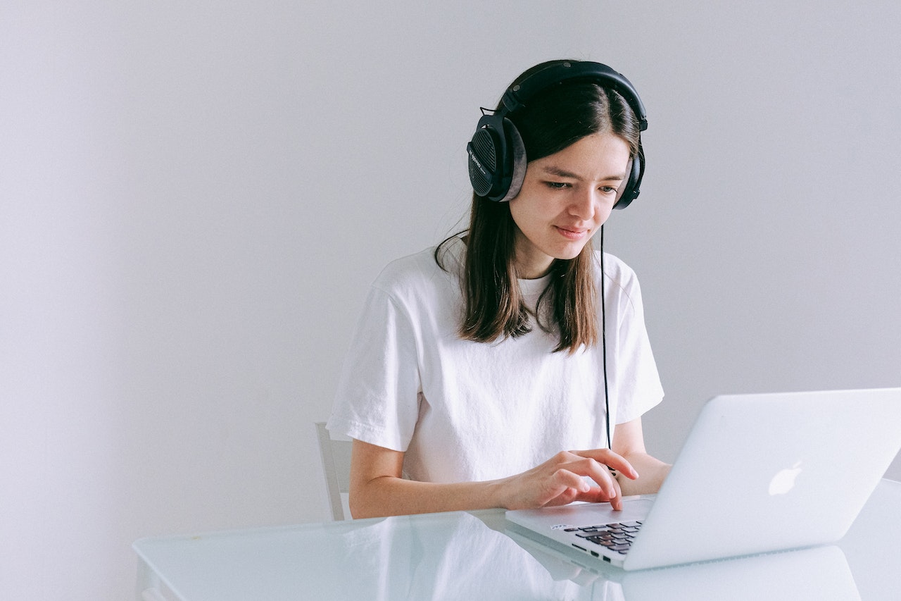 woman wearing headphones and using laptop