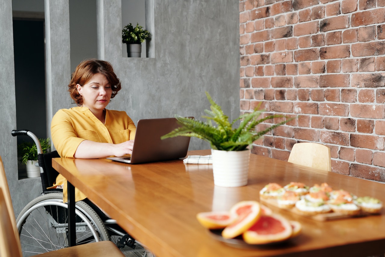 woman on wheelchair using laptop